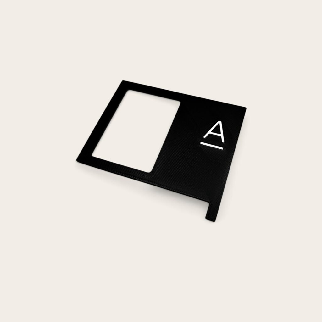Minimalist black matte sign mockup with a cutout frame and white logo.