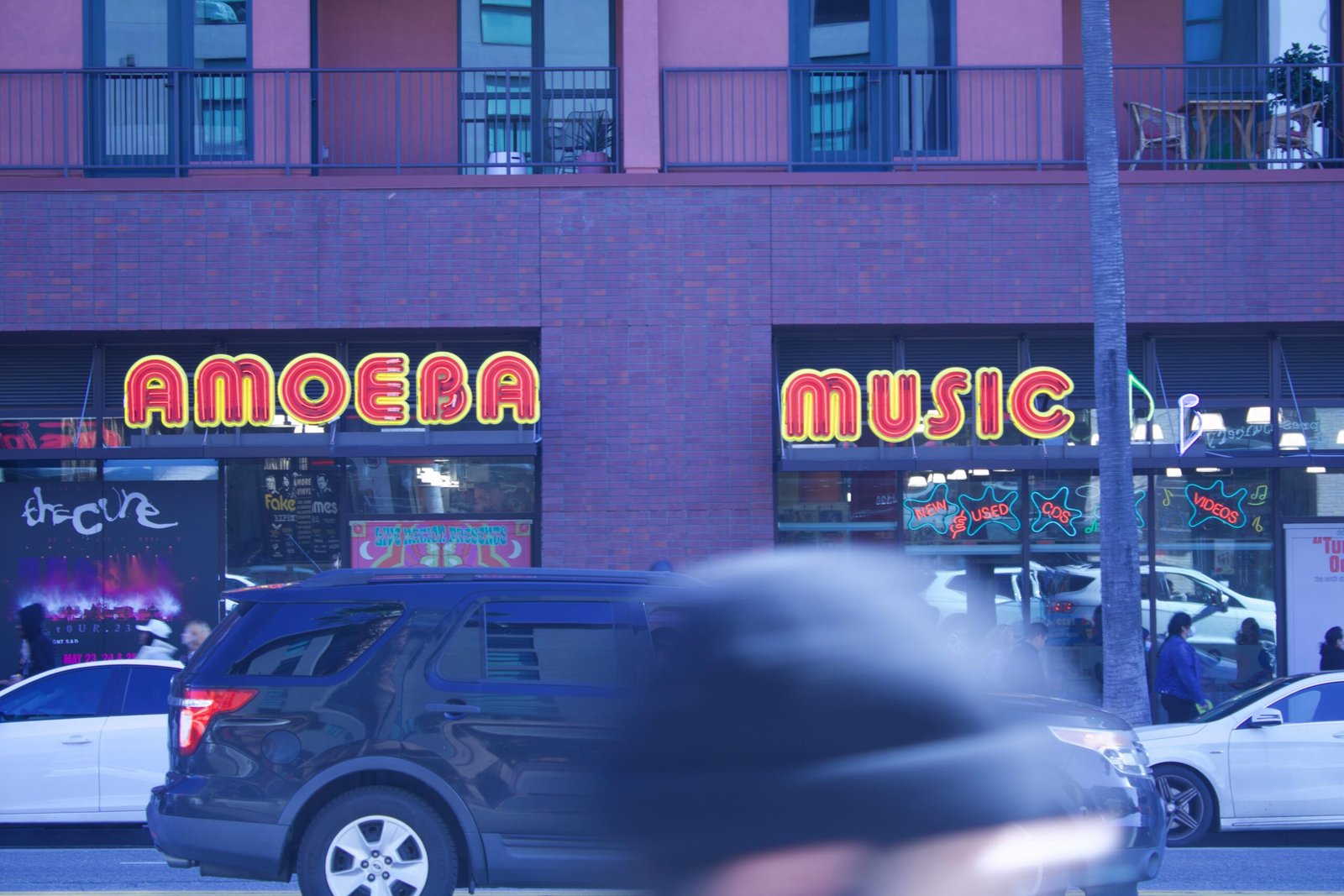 Amoeba Music’s Hollywood storefront with people walking by and a car parked out front.