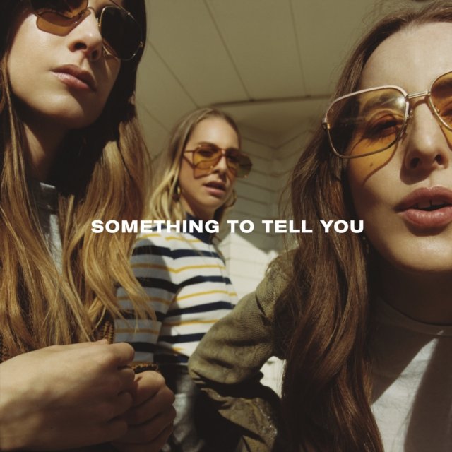 Album cover for HAIMs Something To Tell You featuring three women wearing sunglasses.