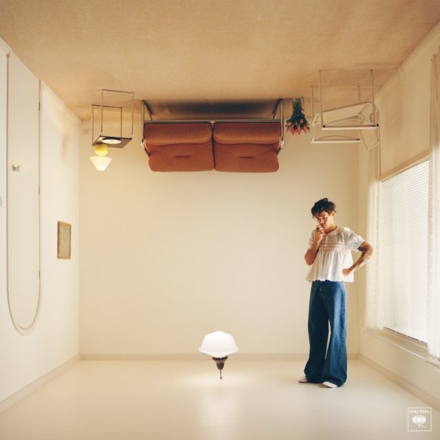 Harry Styles standing in an upside-down living room on the Harrys House album cover.