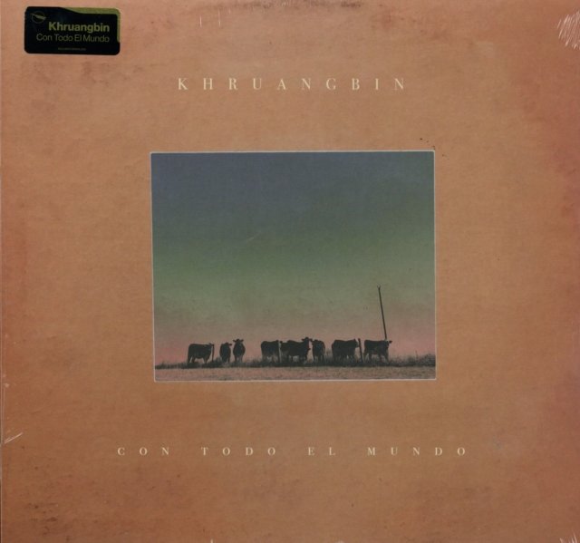 Khruangbins Con Todo El Mundo vinyl album cover featuring silhouetted cows at sunset.
