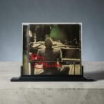 Ray Charles CD album in a clear jewel case on a black display stand.