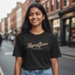 Young woman smiling outdoors on a city street, wearing a black graphic t-shirt.