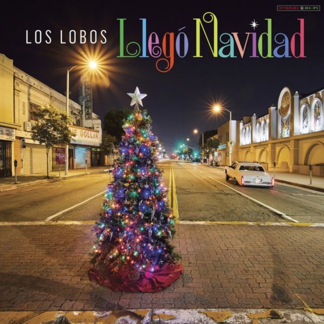Los Lobos Llegó Navidad album cover featuring a glowing Christmas tree on a city street.