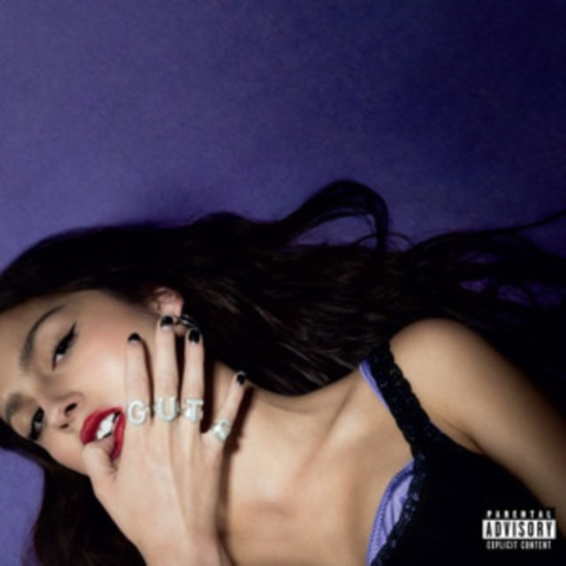 Album cover of Olivia Rodrigos GUTS featuring her wearing silver rings spelling GUTS.